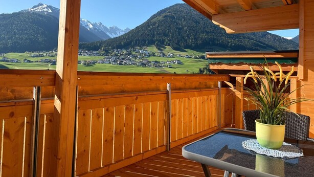 A wooden balcony with a view of a mountain landscape. - Alpenresort Panorama (Oberperfuss)