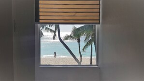 A window with a view of a beach, palm trees, and the ocean. - DiveGurus Boracay Beach Resort (Boracay Island)