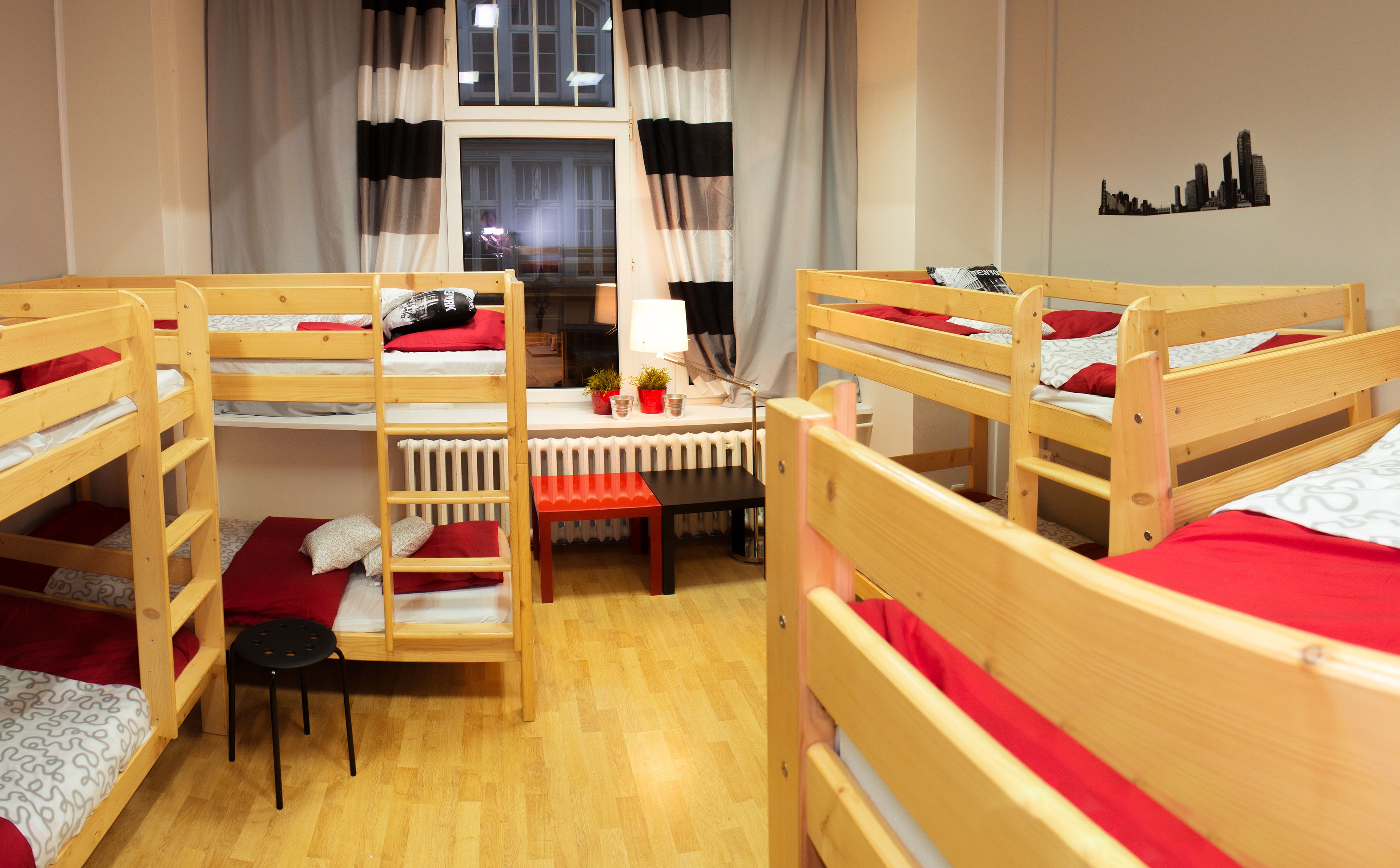 Ein Schlafsaalzimmer mit Etagenbetten, einem Schreibtisch und einer Heizung.