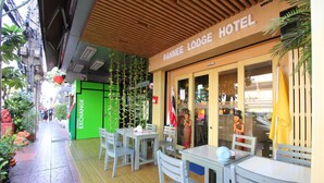 Un hôtel doté d’une terrasse et d’un auvent vert.