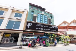 A hotel with a large sign for Pannée Hotel and OYO. There are outdoor seating areas and a 7-Eleven store. - Super OYO 484 Pannee Residence Khaosan (Sha Plus) (Bangkok)