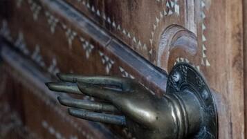 A wooden door with intricate carvings and a brass door handle.