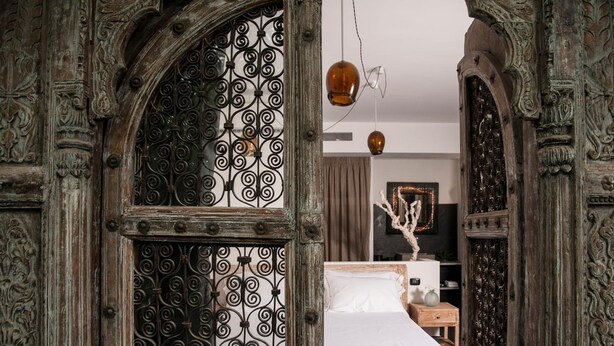 A room with a bed, a decorative wrought iron gate, and a hanging light fixture. - Sevenmaze Charming House (Bari)