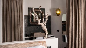 A modern bathroom with a large mirror, a decorative tree sculpture, and a gold wall sconce. - Sevenmaze Charming House (Bari)
