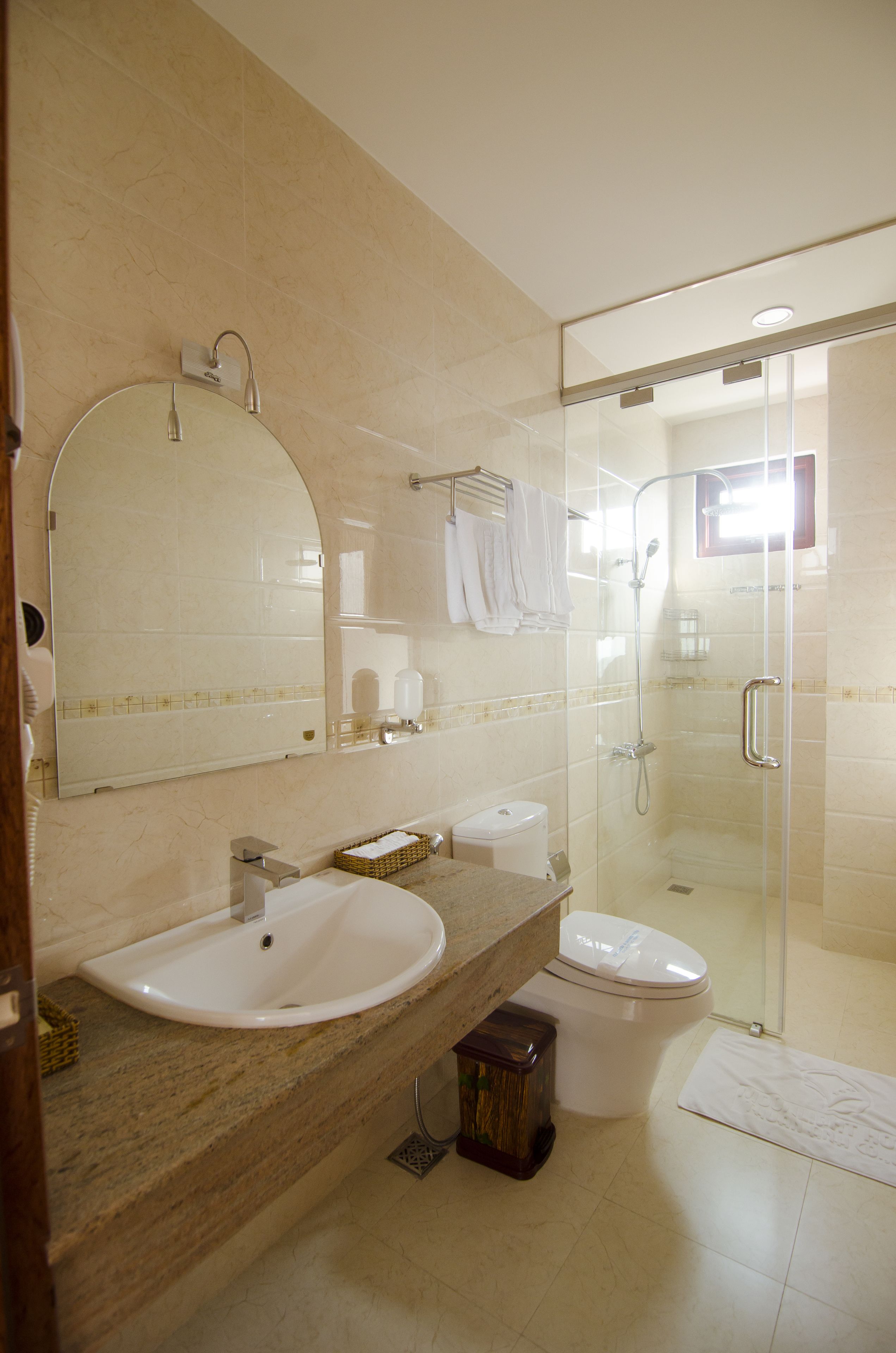 A bathroom with a sink, toilet, and glass-enclosed shower.