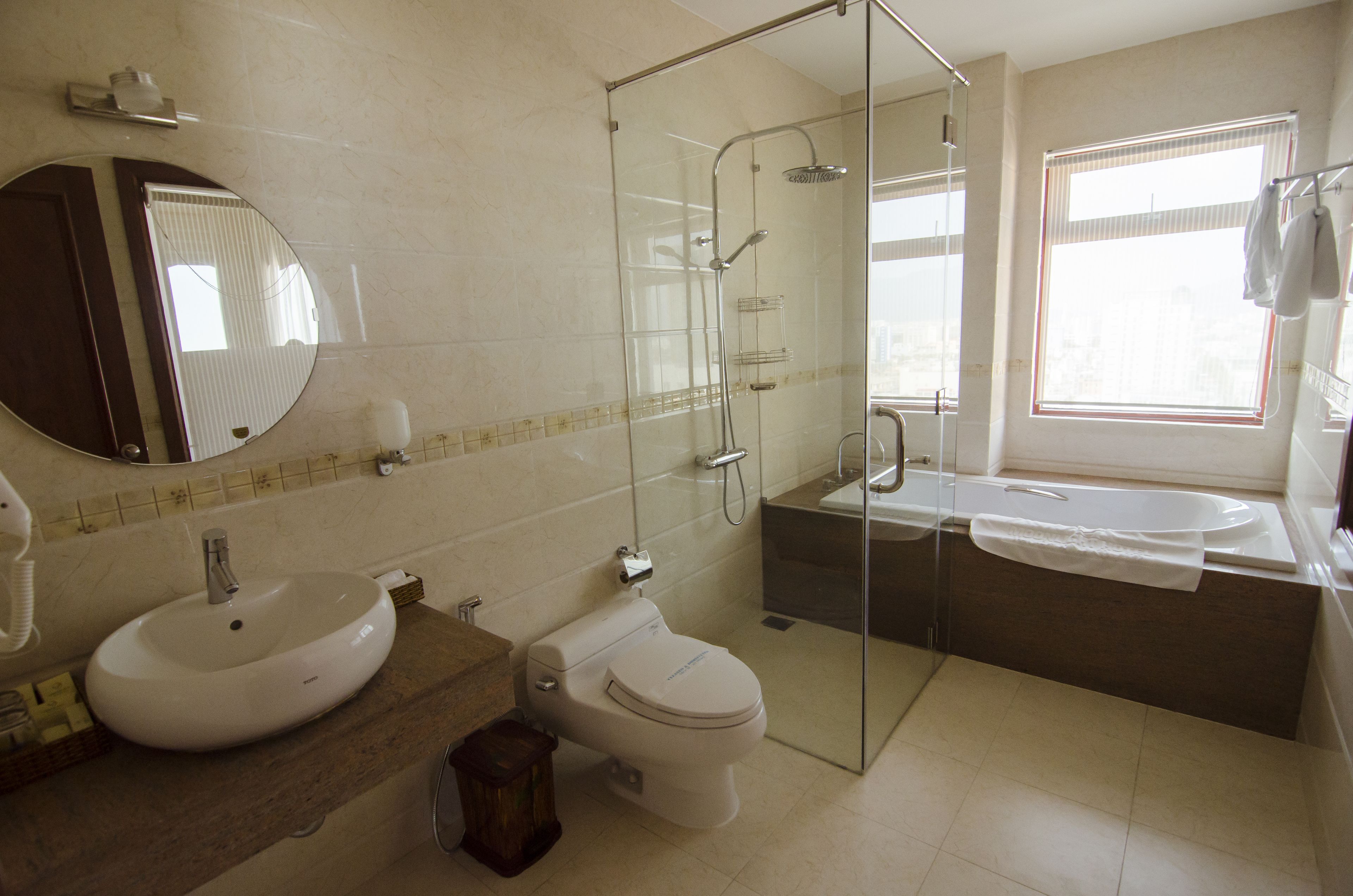 A bathroom with a glass-enclosed shower, a sink, and a toilet.