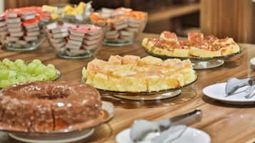 Een buffet met diverse desserts en fruit.