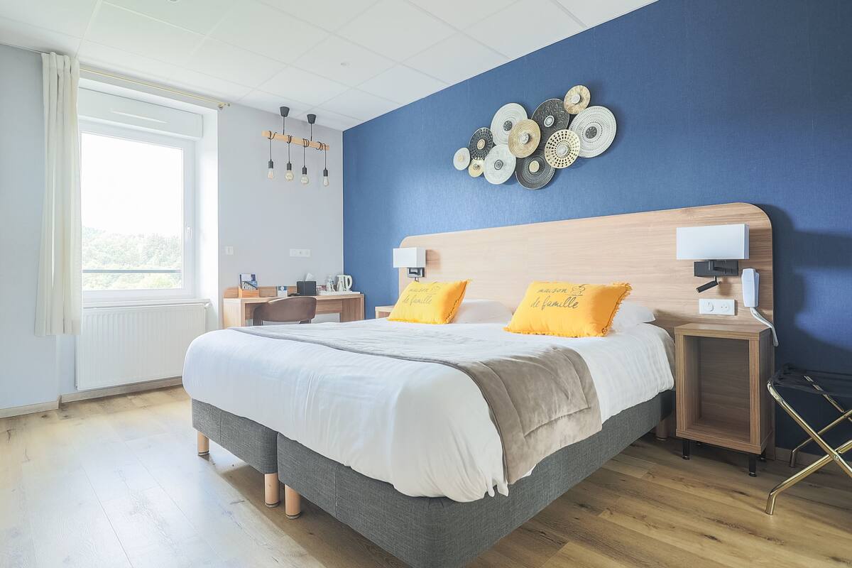 Een moderne slaapkamer met een groot bed, nachtkastjes en uitzicht op de omgeving.