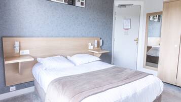 A neatly arranged bedroom with a bed, bedside tables, a wardrobe, and a door.