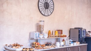 Un bufé de desayuno con diversos alimentos, una máquina de café y un reloj en la pared.