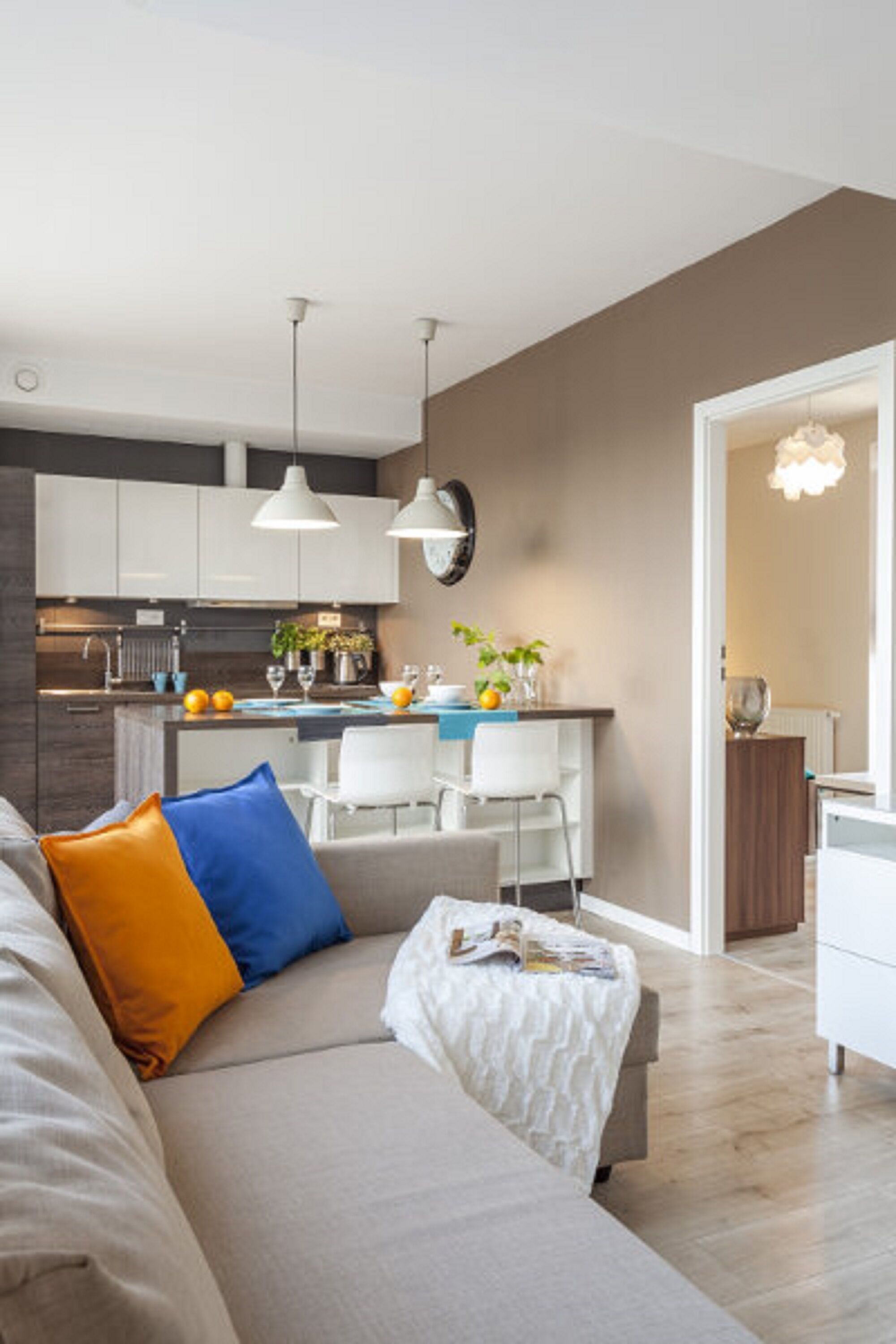 Un salon moderne comprenant un canapé, une table basse et un coin repas avec une table et des chaises.
