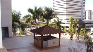 An outdoor patio with a wooden gazebo, tiled flooring, and outdoor seating.