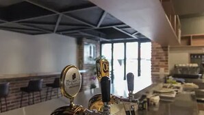 A bar area with a tap labeled "Perrier" and a counter with a brick wall backdrop. - Uniqstay (Busan)