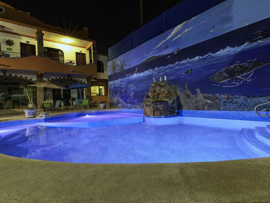 Een buitenzwembad, ligstoelen bij het zwembad