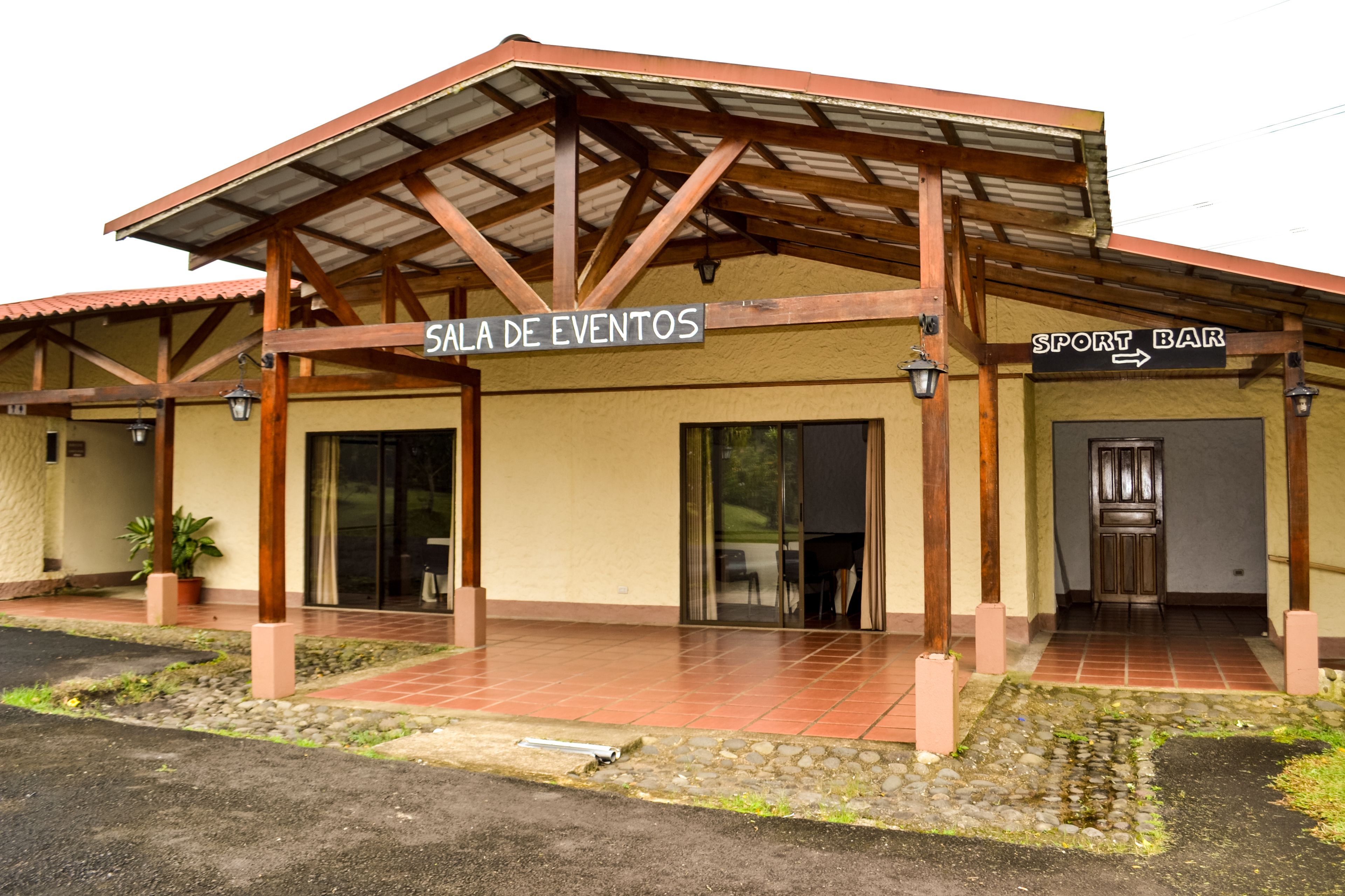 Un bâtiment avec une entrée couverte portant l’inscription « Sala de Eventos » et, à droite, une enseigne indiquant un « Sport Bar ».