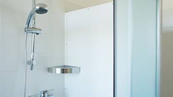 A modern shower with a handheld showerhead and a wall-mounted faucet.