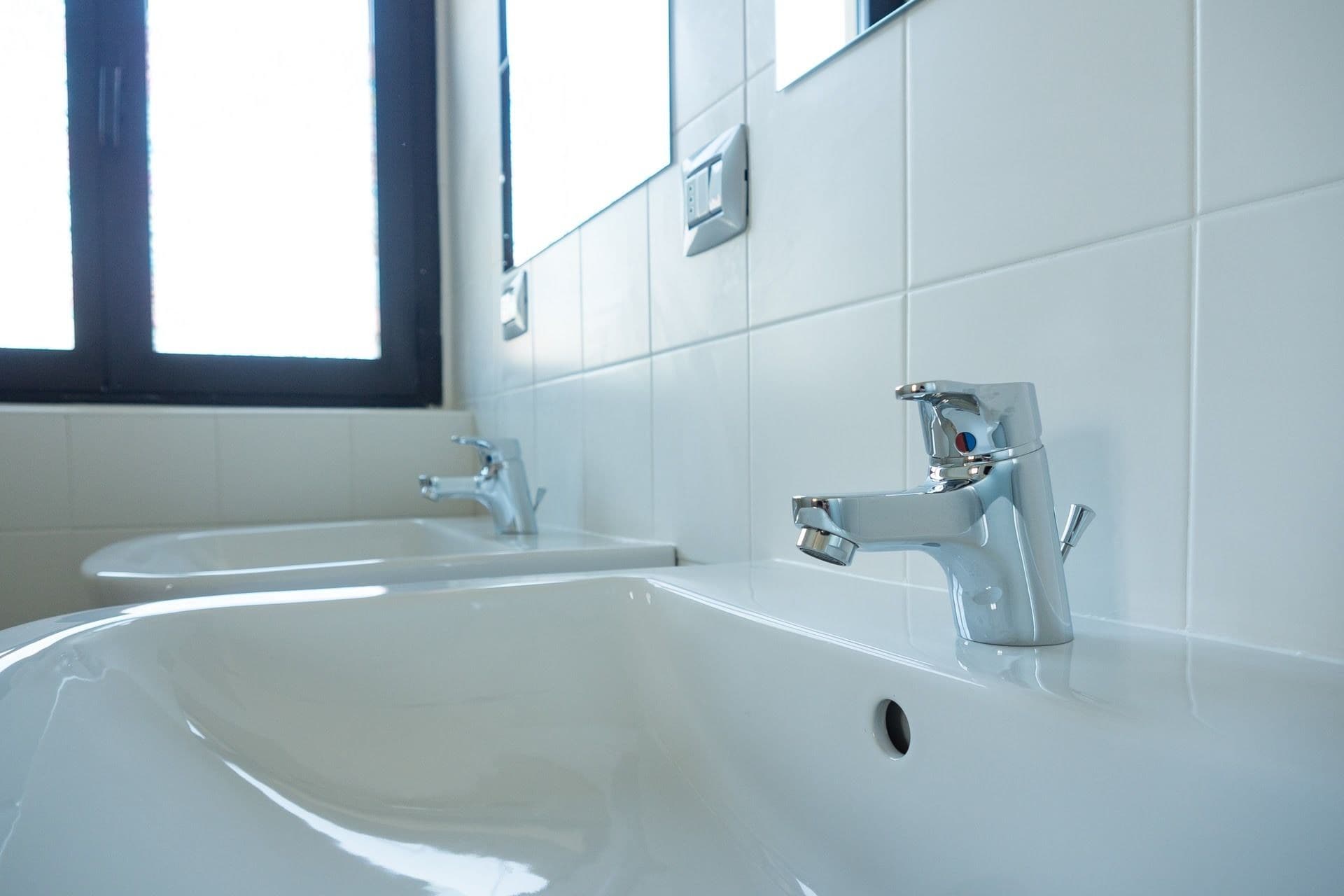 Une salle de bain avec deux lavabos et une fenêtre.