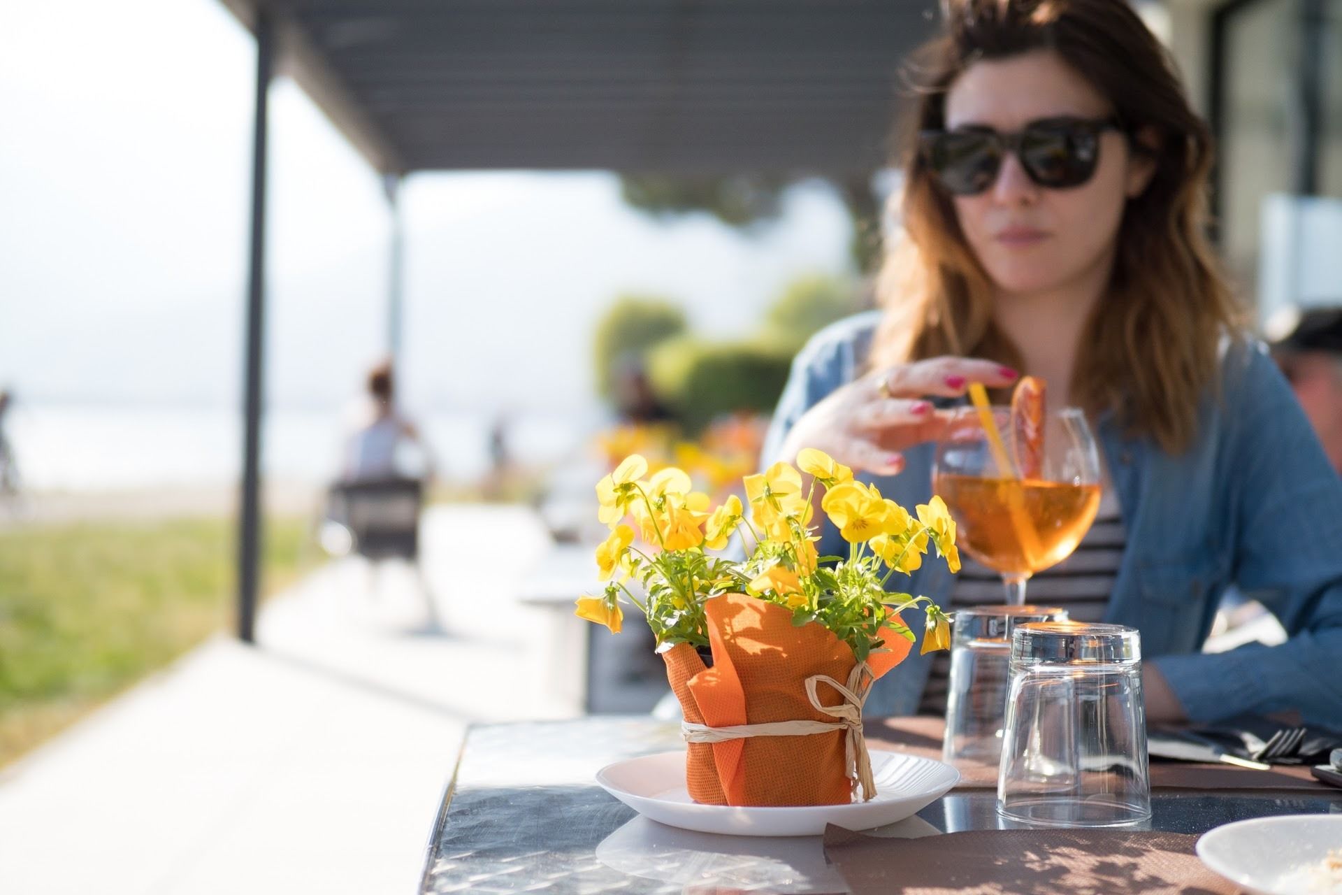 Een tafel met een drankje, een kleine potplant en een zoutvaatje.
