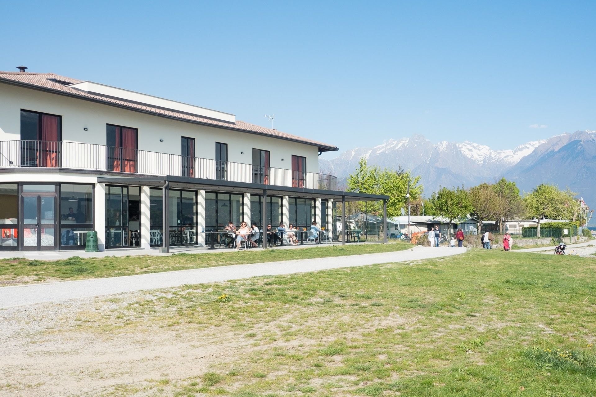 A building with a covered outdoor seating area and a view of snow-capped mountains.