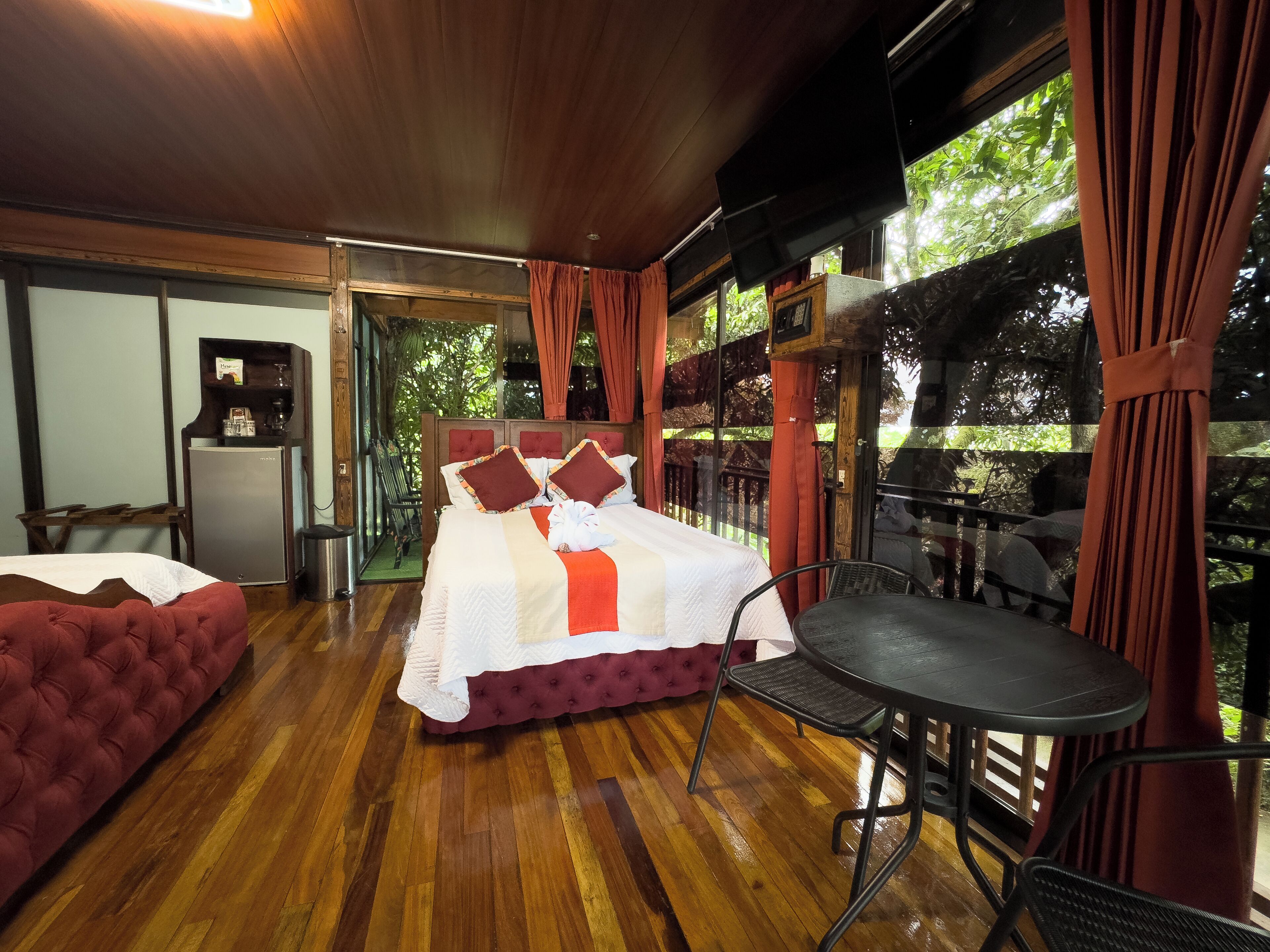 A room with a bed, a small table, and a refrigerator.