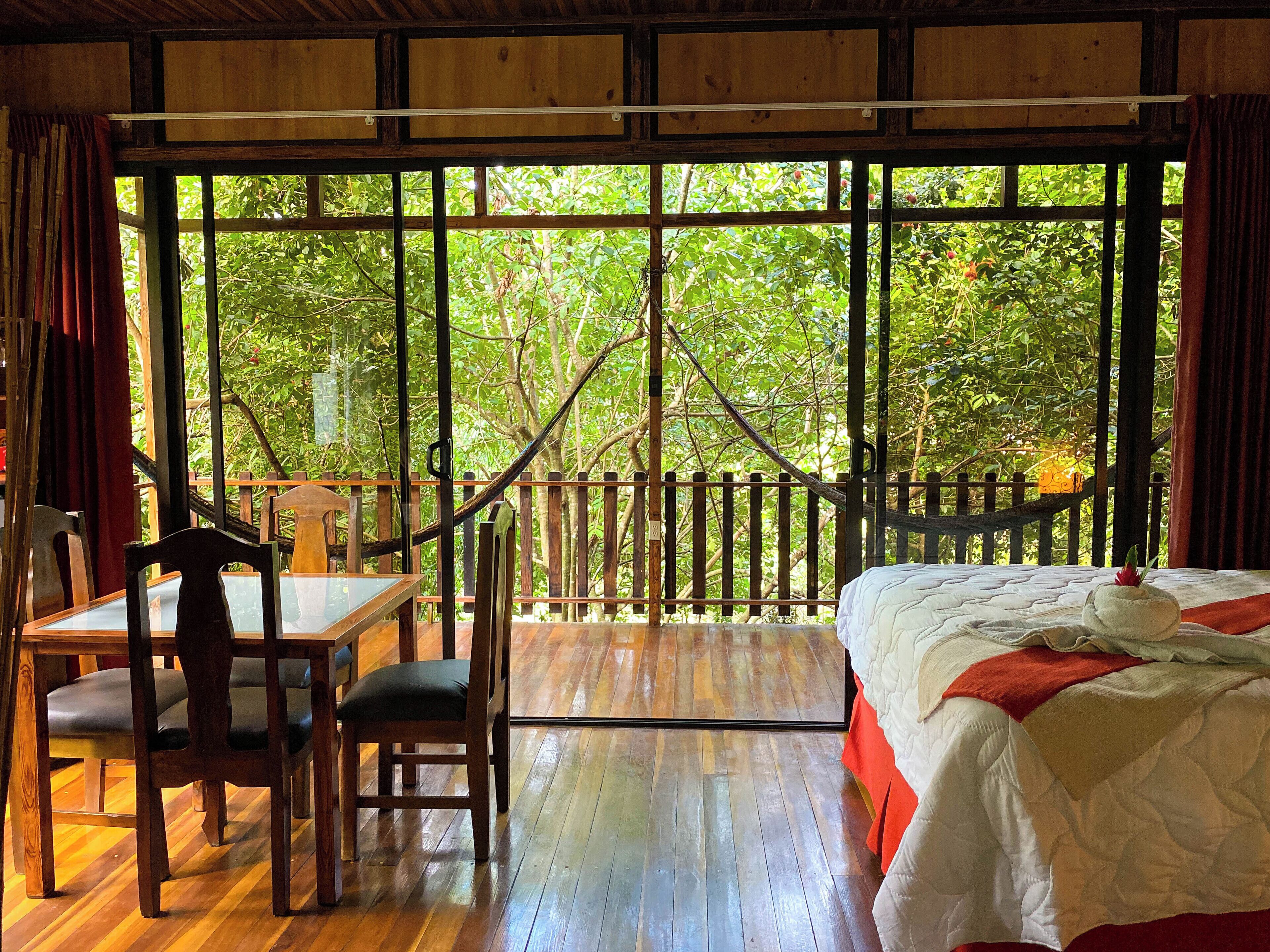 A wooden room with a bed, a table, and chairs.