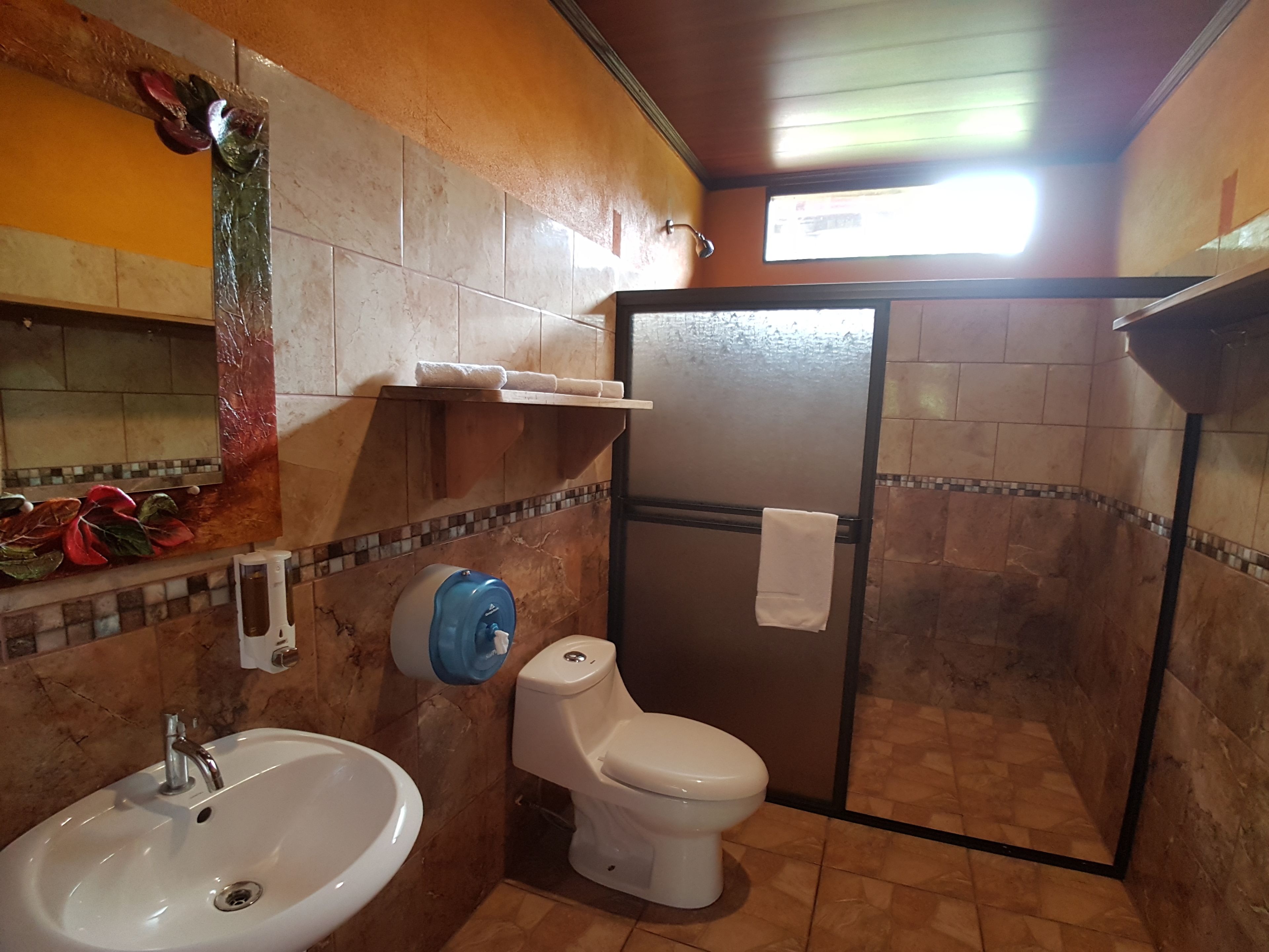 Un baño con lavamanos, inodoro y zona de ducha.