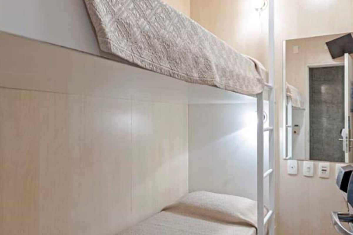 A bunk bed room with a mirror and a small sink.