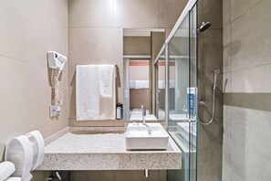 A modern bathroom with a sink, mirror, towel rack, and a glass shower enclosure. - Fast Sleep Guarulhos by Slaviero Hotéis (Guarulhos)