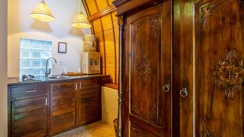 A kitchen with wooden cabinets, a sink, and pendant lights.