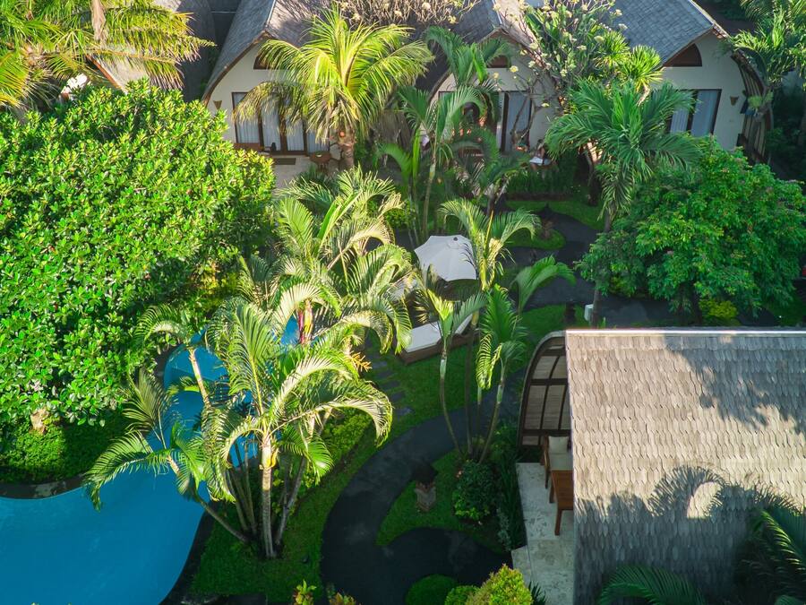 Ein tropisches Resort mit mehreren Villen, üppiger Vegetation und einem Swimmingpool.