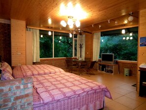 A cozy room with a large bed, a TV, and a dining area. - Feng Ya Yue Zhu (Guanxi)