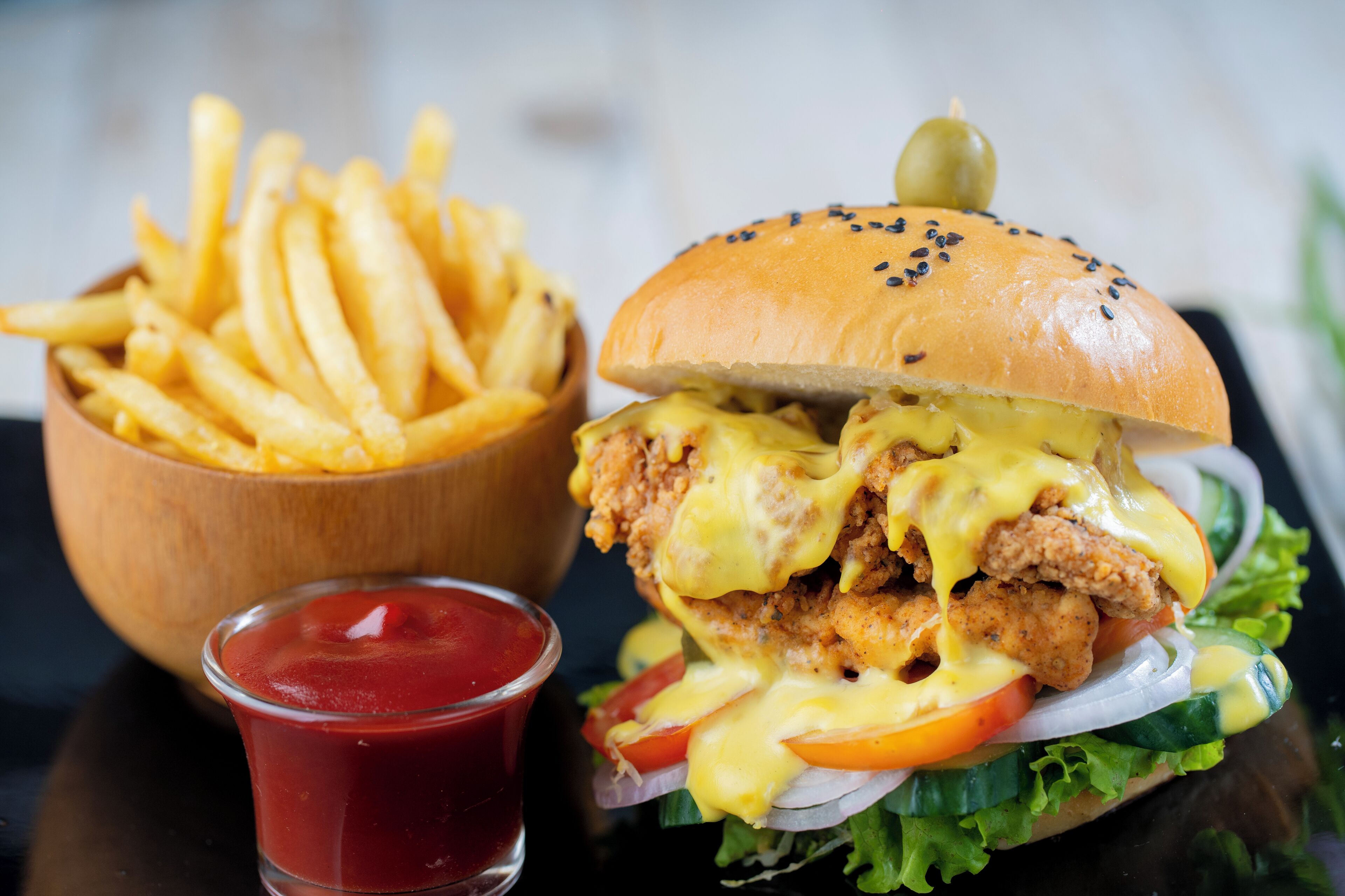 Una hamburguesa de pollo con papas fritas y kétchup.