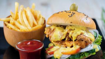 Una hamburguesa de pollo con papas fritas y kétchup.