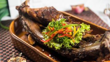 A roasted duck with vegetables on a plate.