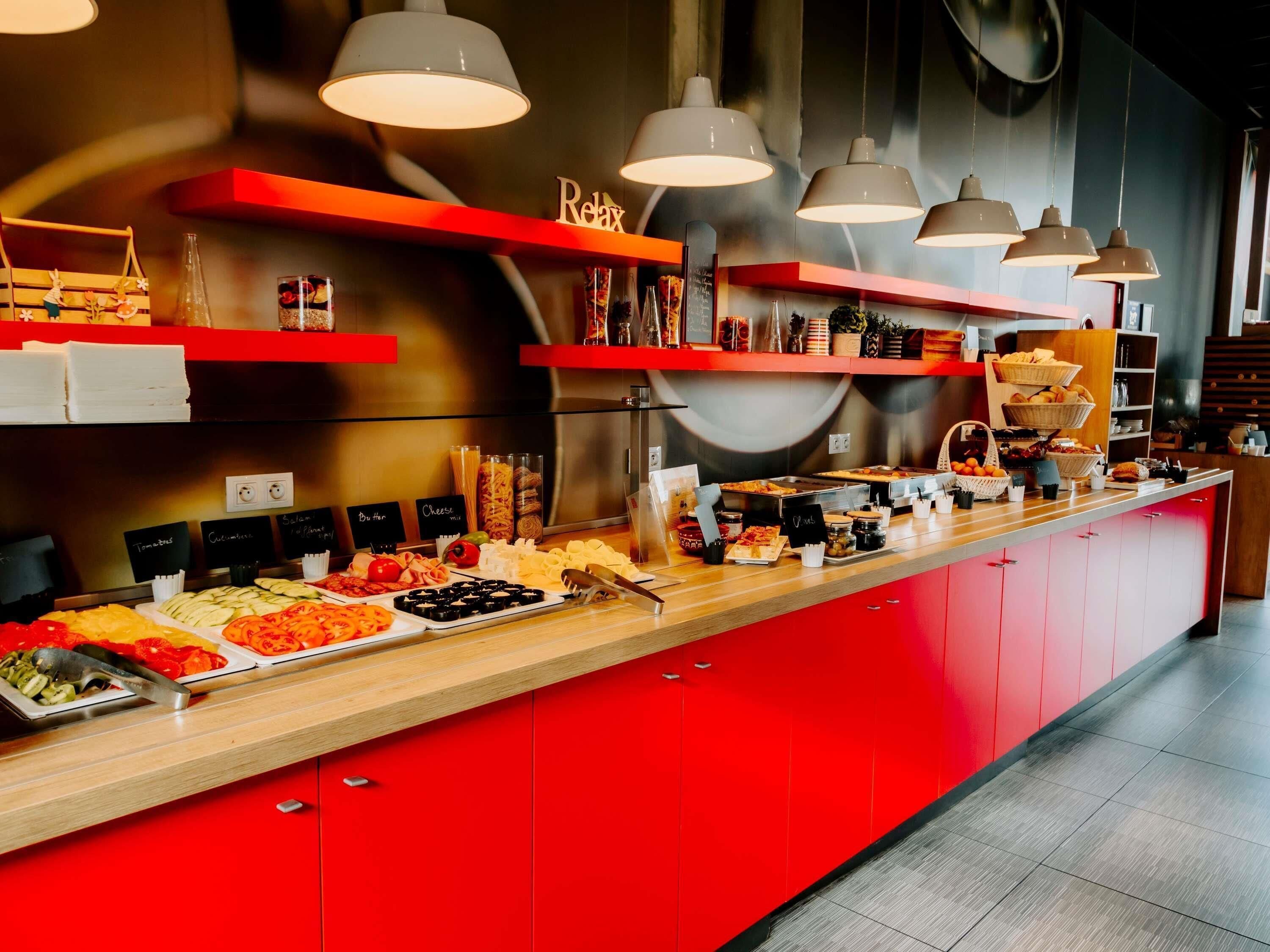 A buffet with various food items and a red counter.