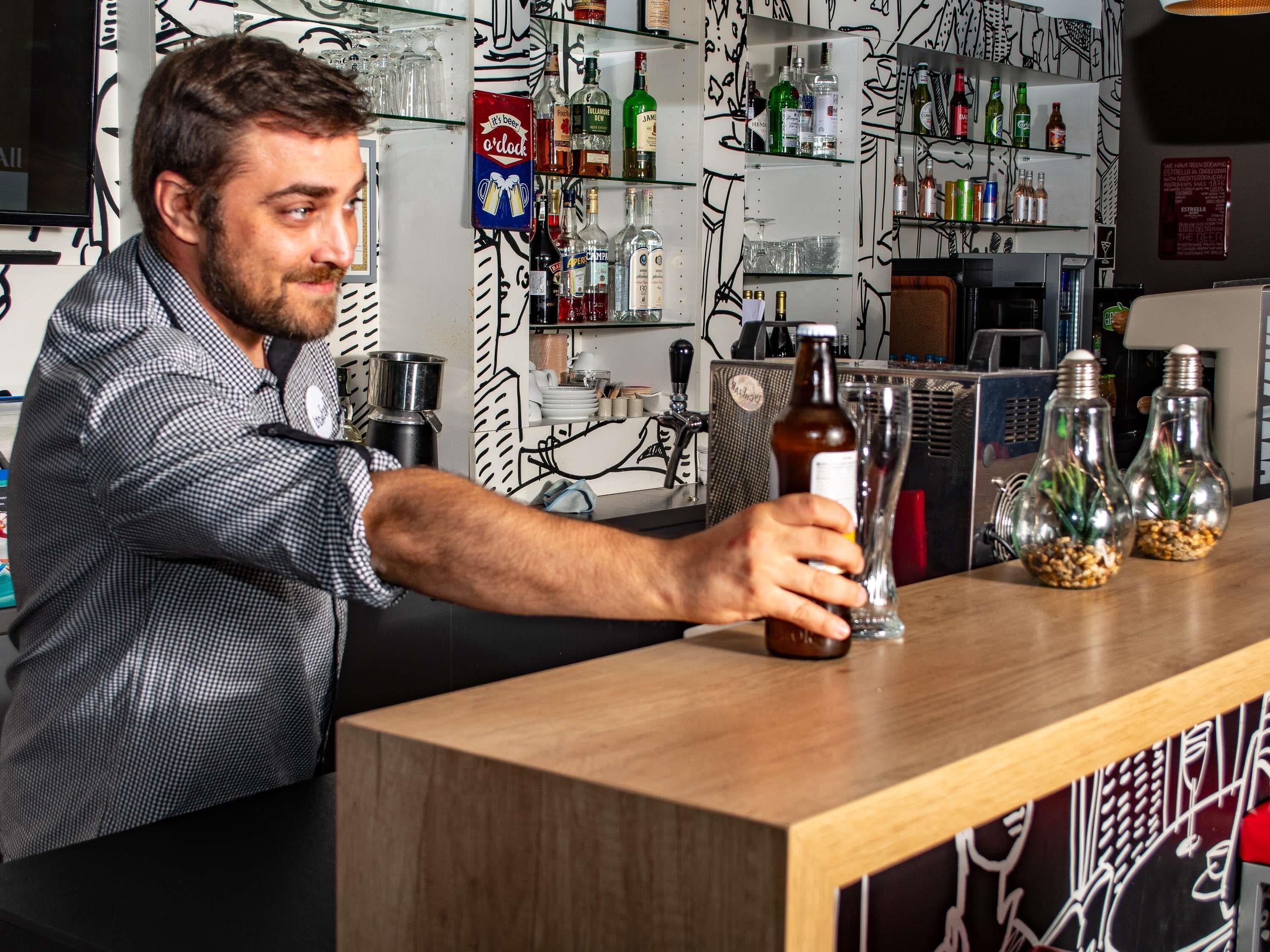 A bar area with shelves of various bottles, a beer tap, and a counter.