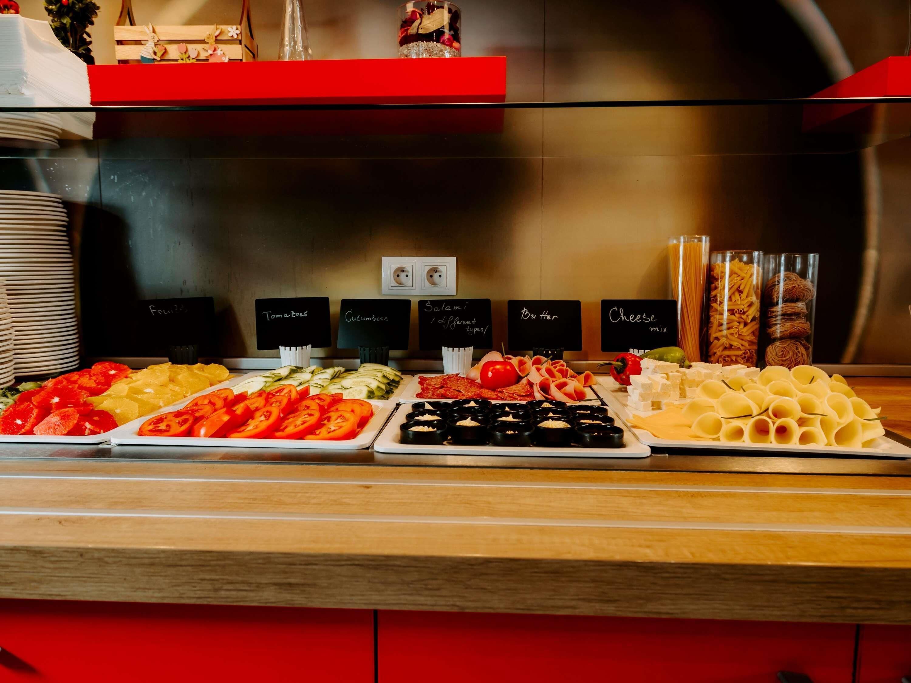 Een buffet met diverse gerechten, waaronder tomaten, komkommers en kaas.