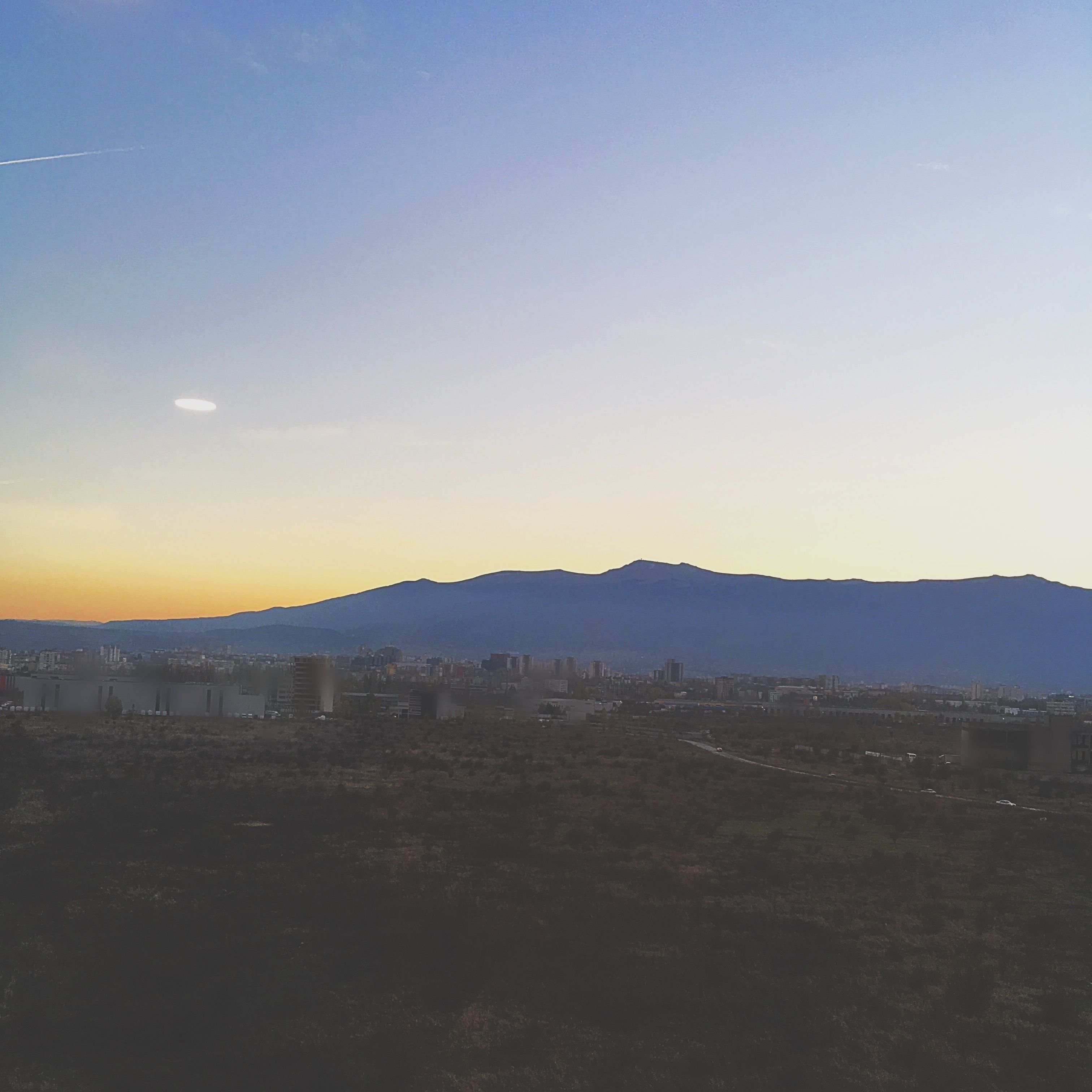A cityscape with a mountain in the background.