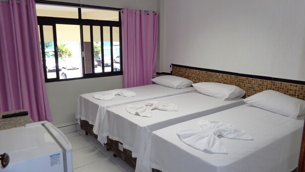 A hotel room with two beds, a window with curtains, a tiled floor, and a small refrigerator. - Pousada Damasco (Brasília)