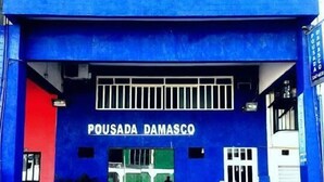 A blue building with a sign reading "POUSADA DAMASCO". - Pousada Damasco (Brasília)
