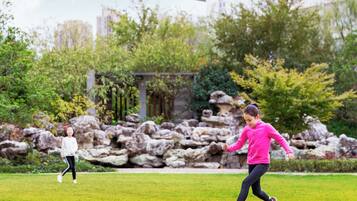 Guests can enjoy a well-manicured lawn perfect for outdoor games and relaxation surrounded by lush greenery and modern architecture.