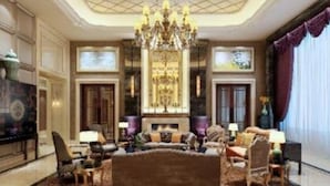 Un salon luxueux avec un grand canapé, des fauteuils, un lustre et une cheminée.