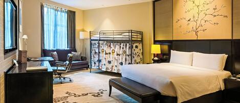 A hotel room with a bed, desk, chair, and a large window with curtains.