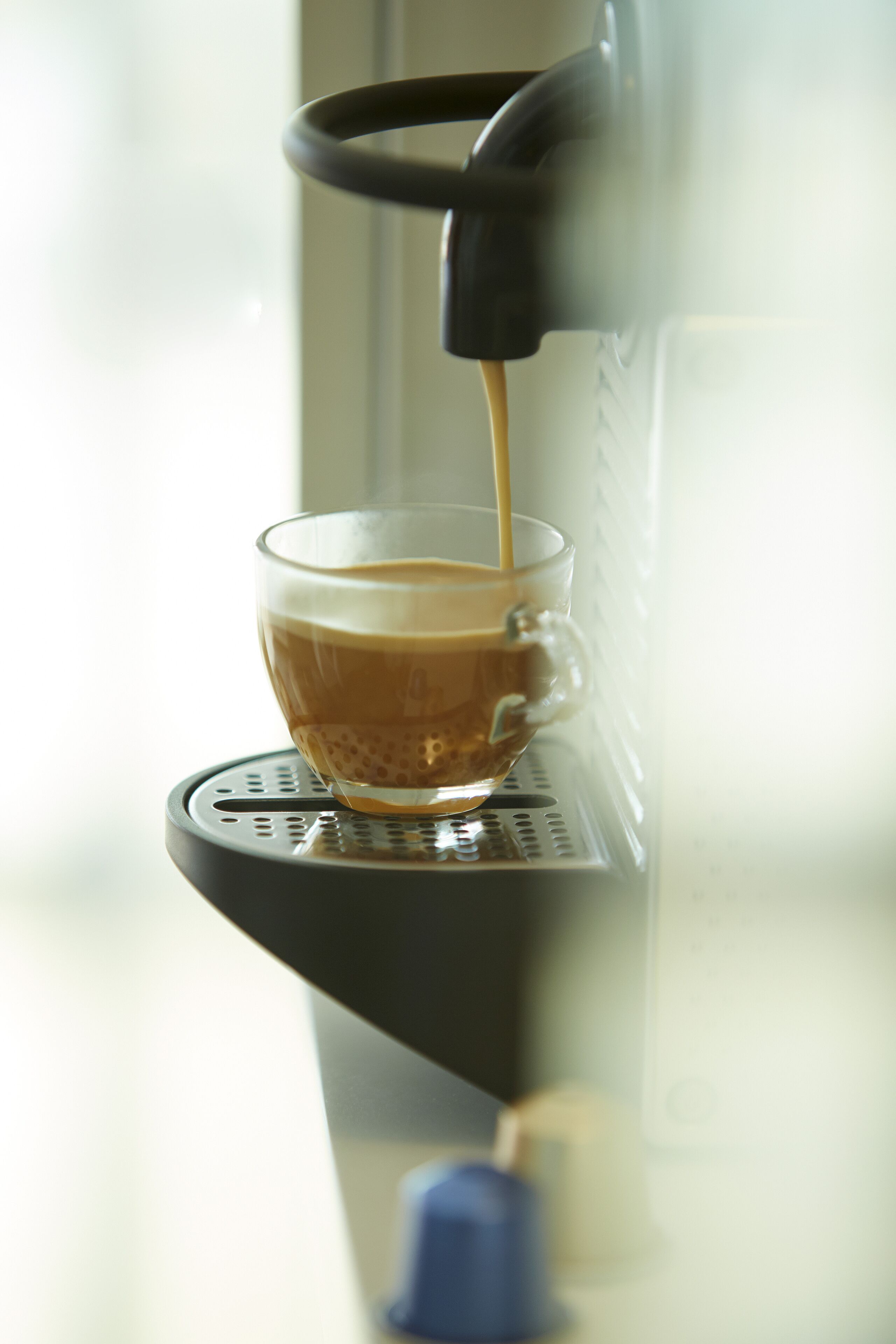 A coffee machine dispensing coffee into a cup.