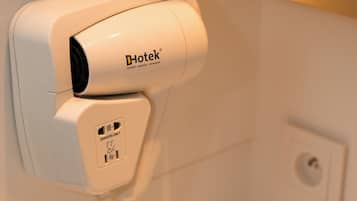 A hair dryer mounted on a wall in a bathroom.