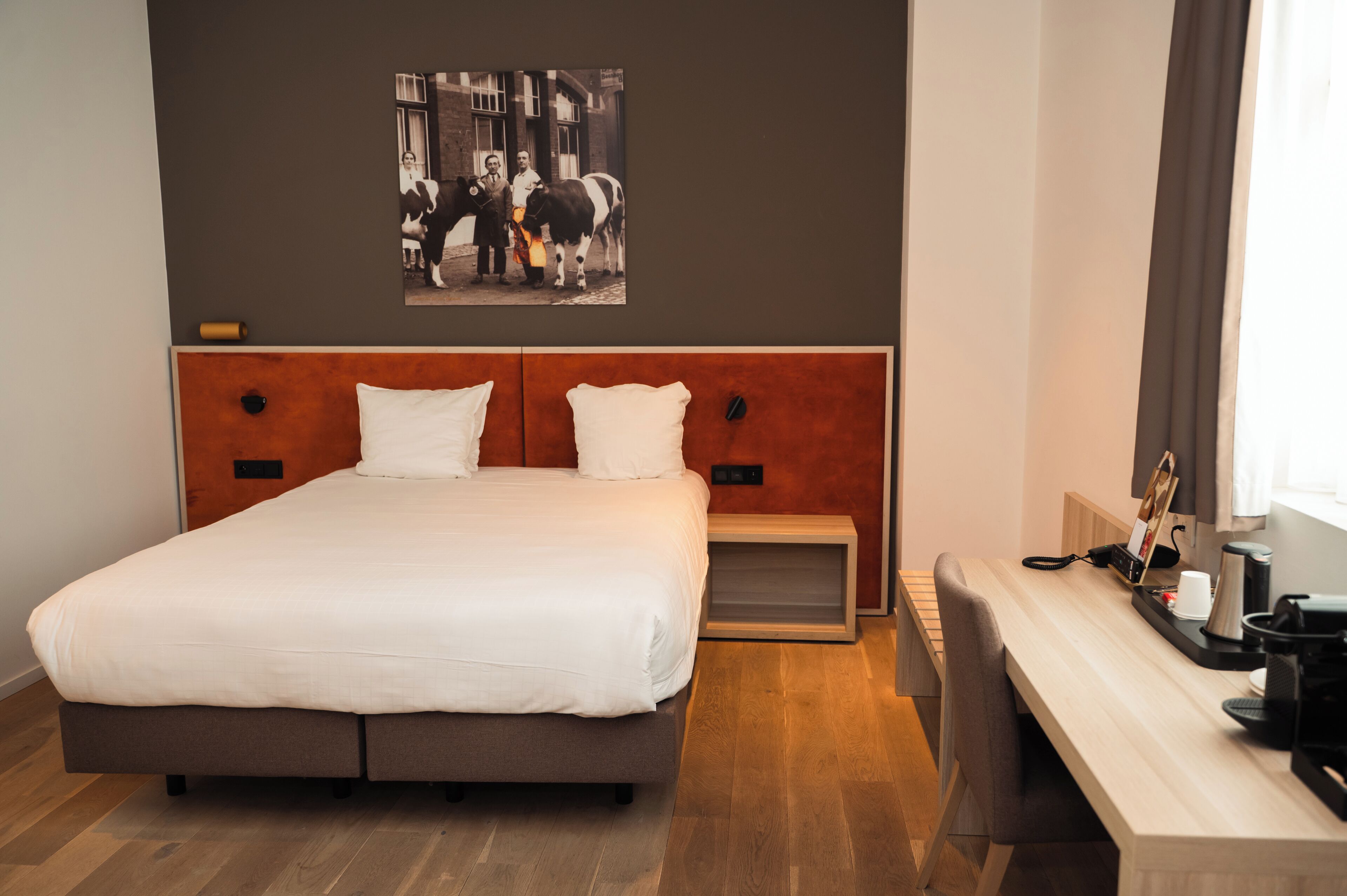 Una habitación de hotel con una cama, mesita de noche y cafetera.