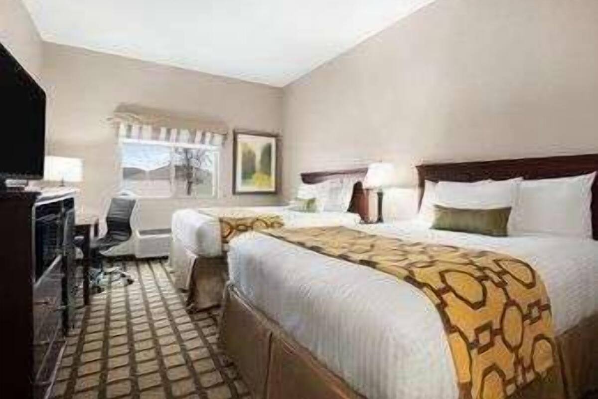 Een hotelkamer met een bed, een bureau, een stoel en een raam.