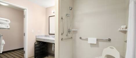 A modern bathroom with a shower, a toilet, and a sink. There is a towel rack and a small shelf.