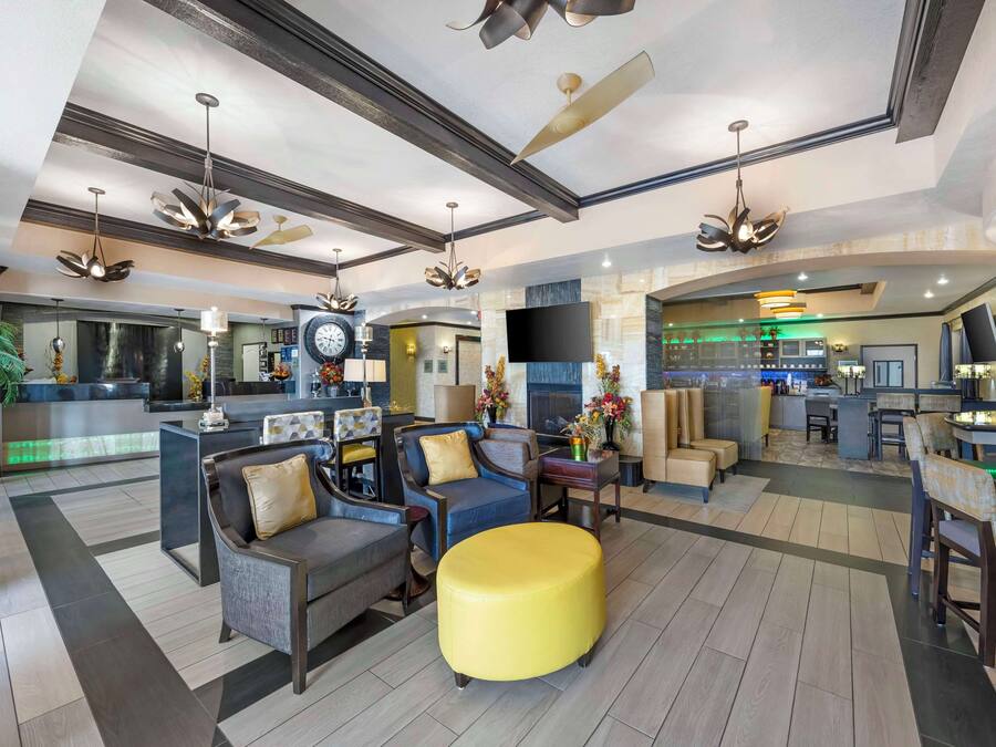 A spacious lobby with modern furniture, a bar area, and a kitchen in the background.