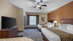 A hotel room with a bed, a TV, a ceiling fan, and a window with curtains. - Best Western North Edge Inn (Dodge City)